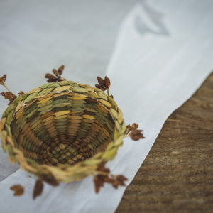 Intricately hand-woven miniature basket usiing dried rushes and seed head detailing