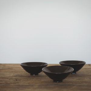 Small pedestal bowls with a shiny glaze.