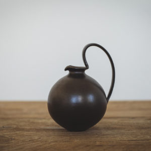Black flagon shaped jug/vase with large looped handle. Matt black finish