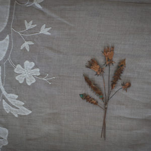 Copper thistle shown on an embroidered white tablecloth