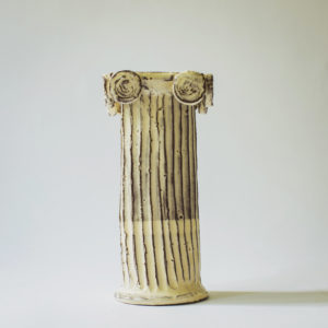 off-white Grecian column vase with vertical ridges. Shown on a white backdrop