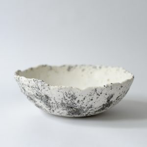white and grey, heavily textured dining bowl, set against a white backdrop.