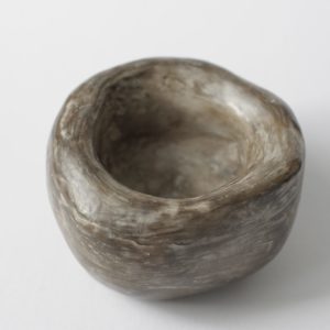 A hand moulded, unfired clay bowl
