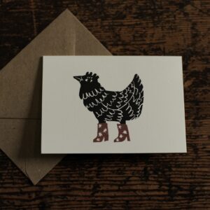 lino cut print of a hen wearing star patterned boots