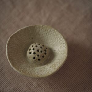 Small ceramic dish with a perforated middle to add stems to.