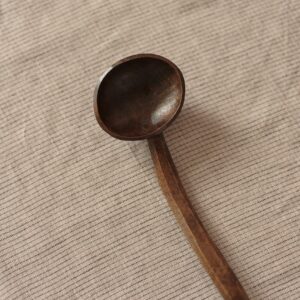 Close up detail of a dark wooden spoon.