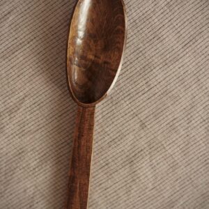 Close up detail of a dark wooden hand carved spoon