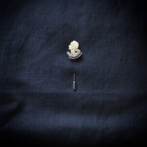 Vintage coin pin featuring a lady’s head.